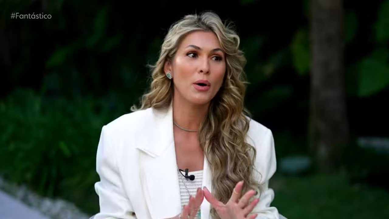 Lívia Andrade falando durante entrevista ao Fantástico com expressão séria e gesticulando com as mãos