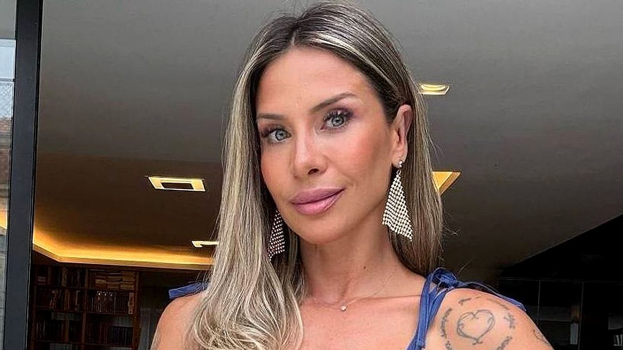 Influenciadora fitness posa com vestido azul e brincos longos em foto publicada nas redes sociais