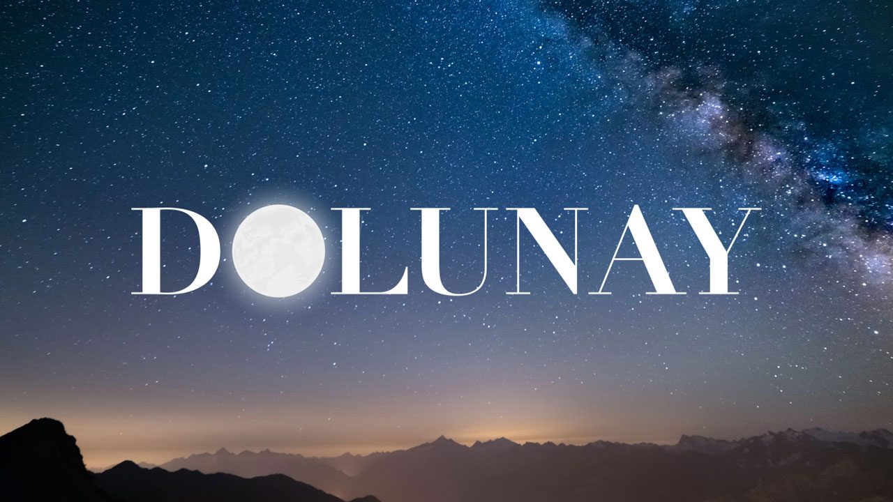 Logo da novela Dolunay com letras brancas e lua cheia formando a letra O sobre céu estrelado e montanhas ao fundo
