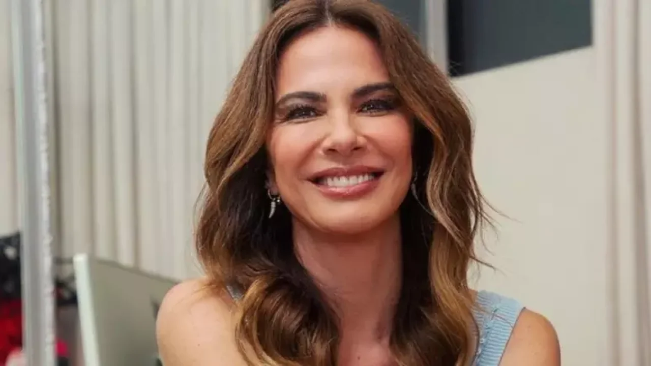 Luciana Gimenez sorrindo durante gravação nos bastidores de programa de TV