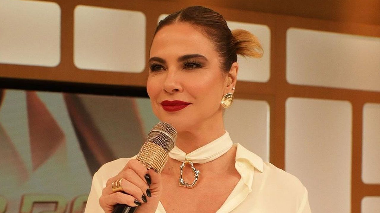 Luciana Gimenez segurando microfone com detalhe em pedrarias durante gravação do Superpop