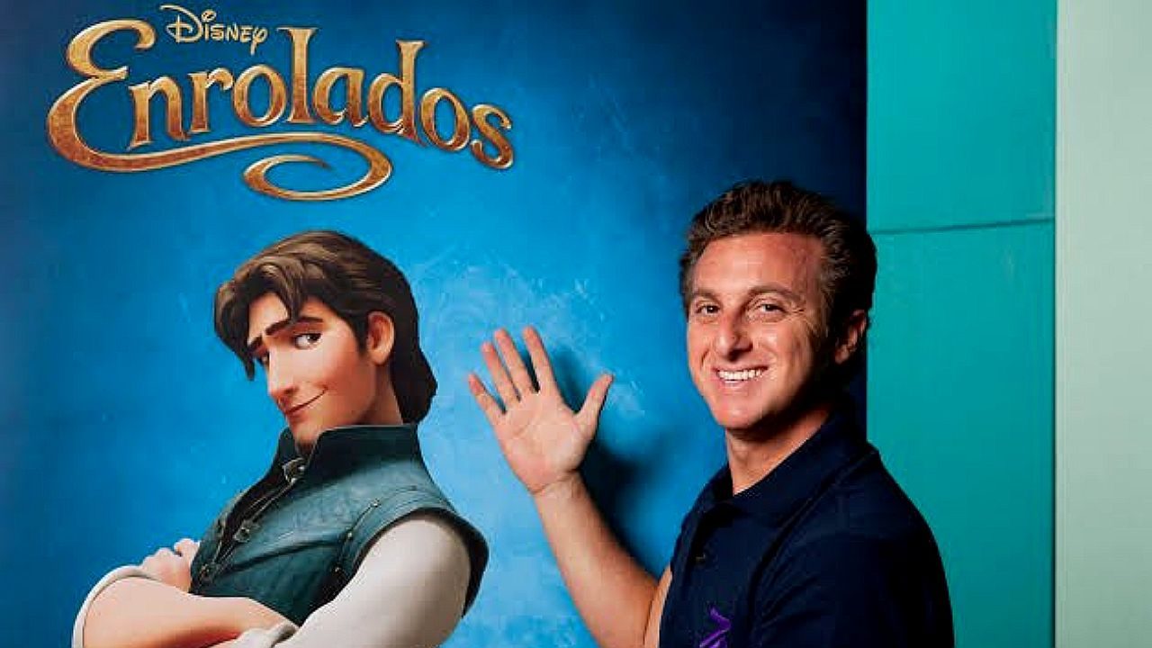 Luciano Huck posa ao lado de pôster do filme Enrolados durante evento de divulgação da Disney
