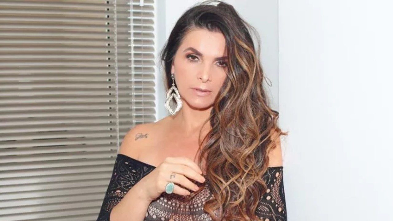 Luiza Ambiel posa com vestido preto e brincos longos em ensaio fotográfico com cabelo ondulado sobre os ombros