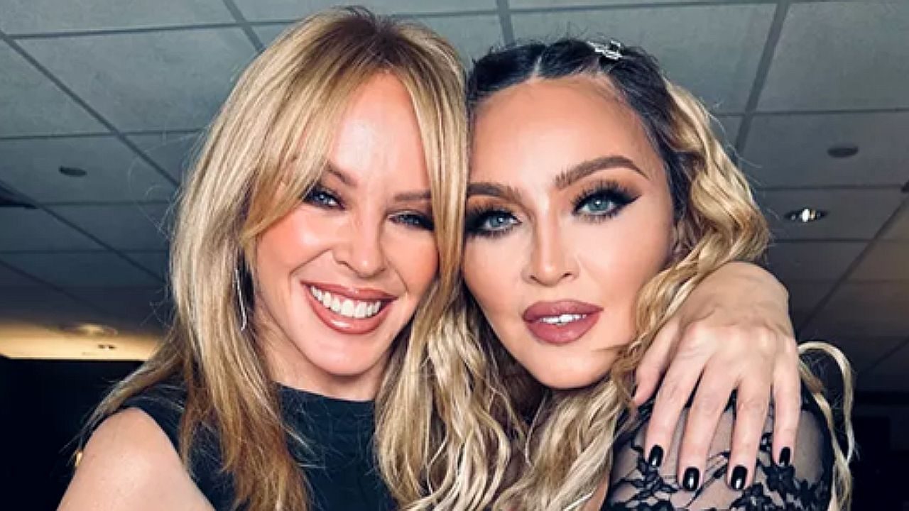 Madonna e Kylie Minogue abraçadas nos bastidores de evento com sorrisos para a câmera