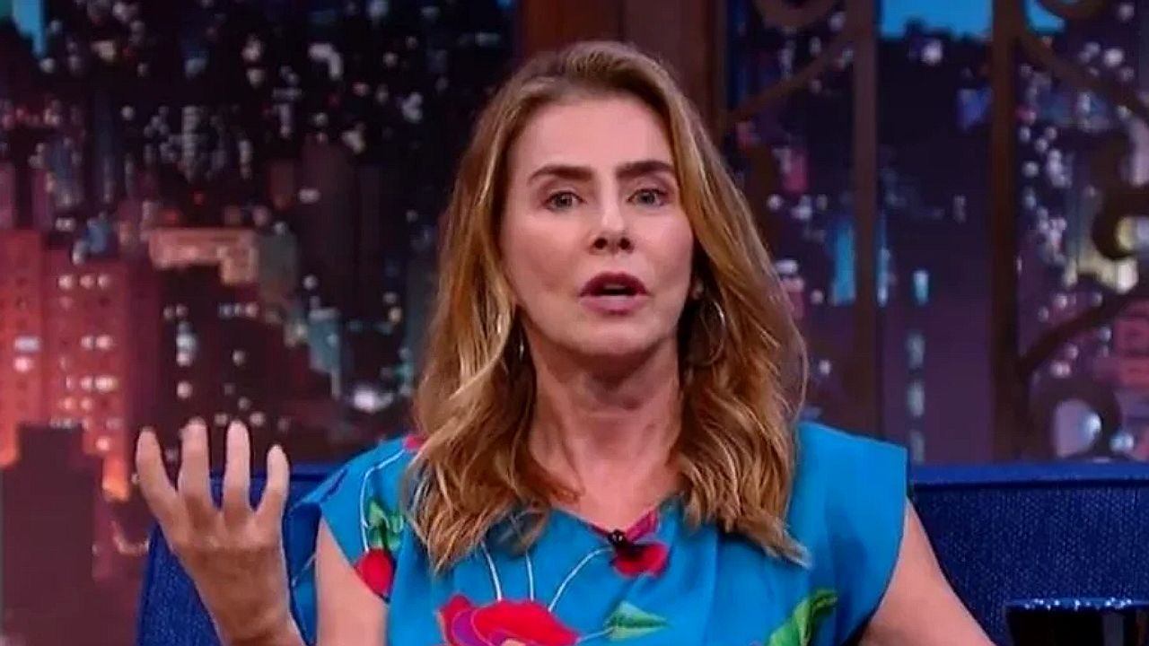 Maitê Proença aparece parcialmente em estúdio com gráficos e textos sobrepostos na tela em cena de programa televisivo