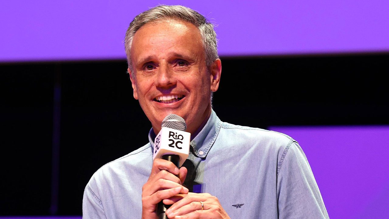 Manuel Belmar, executivo da Globo, sorri enquanto fala em um microfone com o logo do evento Rio2C durante palestra no palco
