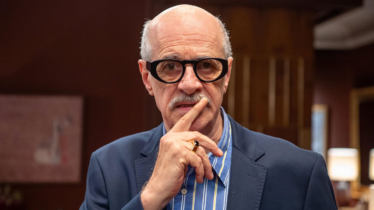 Marcos Caruso caracterizado como Sérgio com expressão séria em cena da novela Elas por Elas