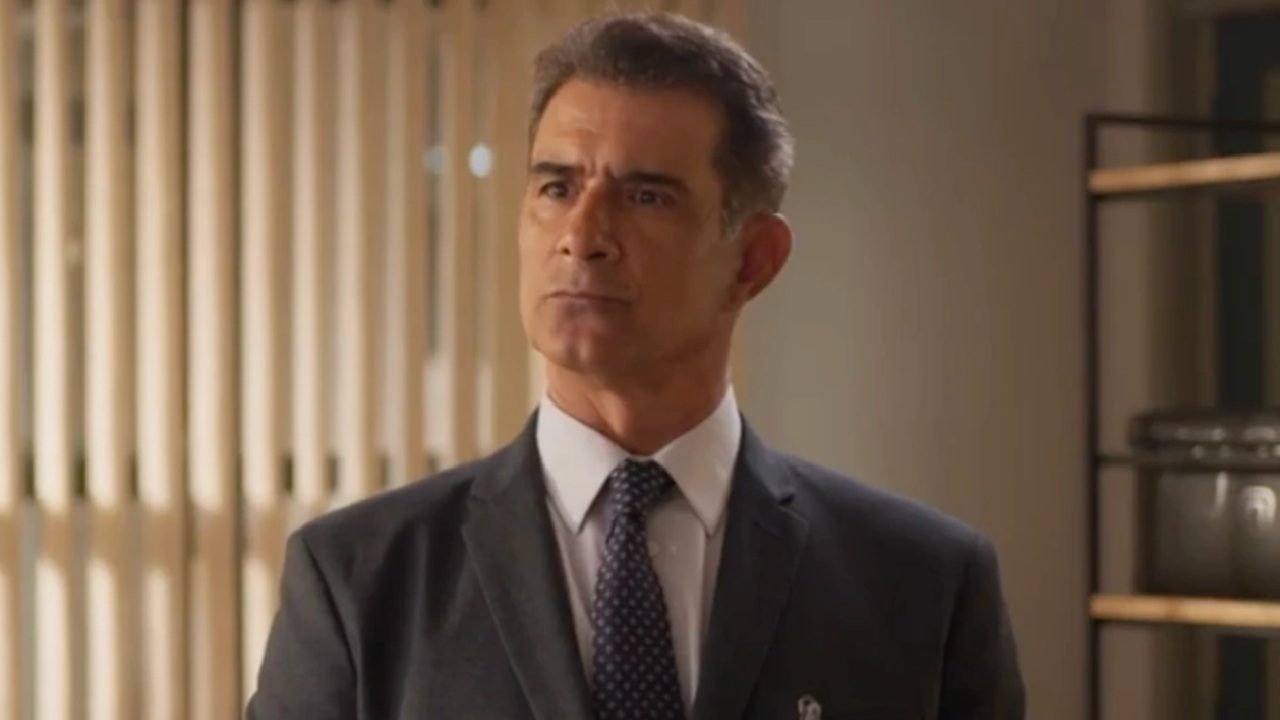 Marcos Pasquim de terno e gravata aparece em ambiente interno bem iluminado, com expressão séria e olhar firme, transmitindo autoridade ou preocupação