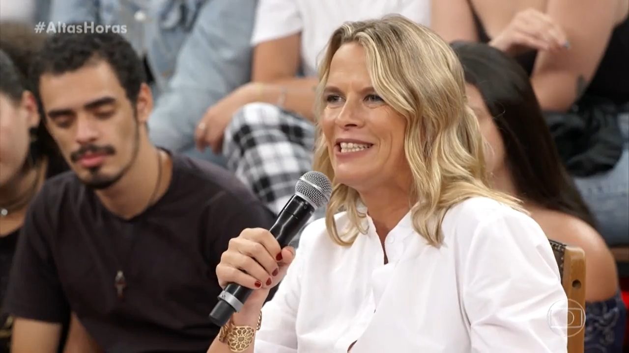 Mariana Becker fala ao microfone durante participação no Altas Horas com plateia ao fundo