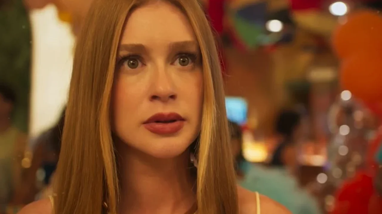 Marina Ruy Barbosa em cena tensa de novela, com expressão surpresa e decoração festiva ao fundo