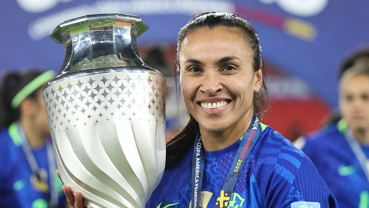 A jogadora Marta sorri para a câmera enquanto segura o troféu da Copa América Feminina conquistado pela Seleção Brasileira