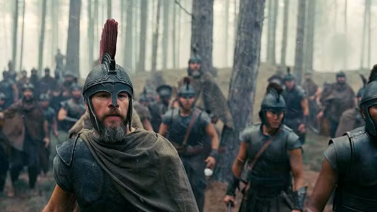 Matt Damon com armadura e capacete lidera soldados em cena de batalha no filme A Odisseia