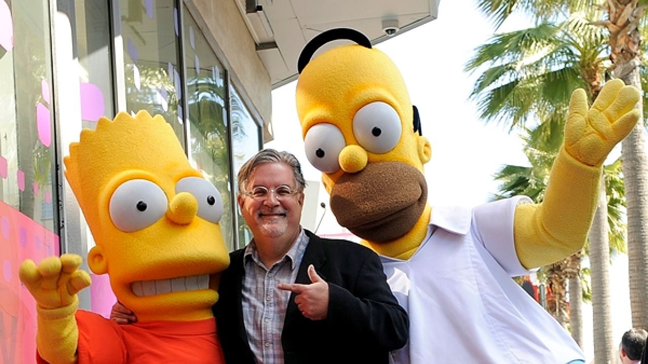 Matt Groening posa entre personagens Bart e Homer Simpson durante evento promocional da série Os Simpsons