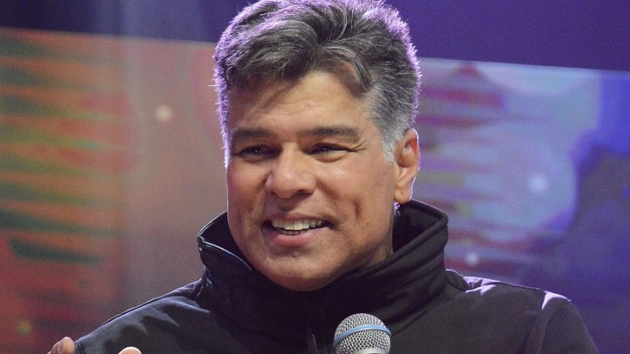 Maurício Mattar sorri enquanto segura microfone durante participação em evento