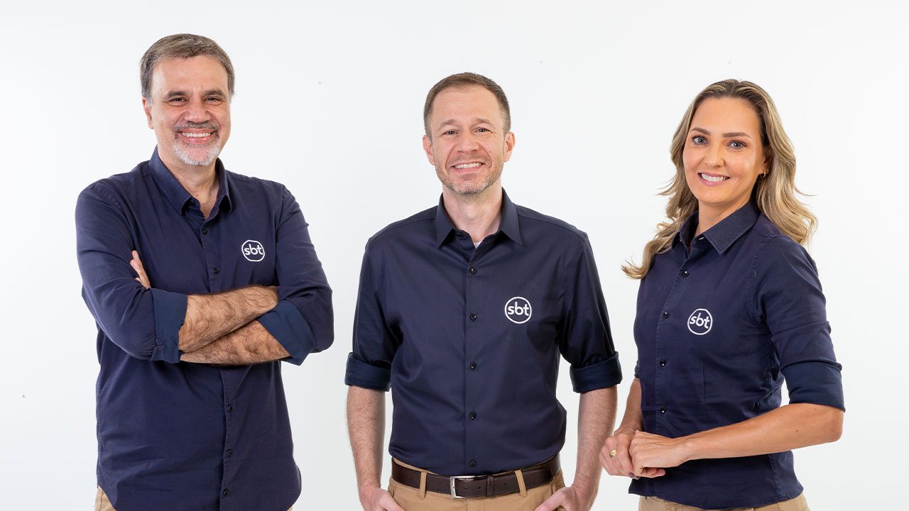 Mauro Beting, Tiago Leifert e Nadine Basttos posando com uniforme do SBT em fundo branco