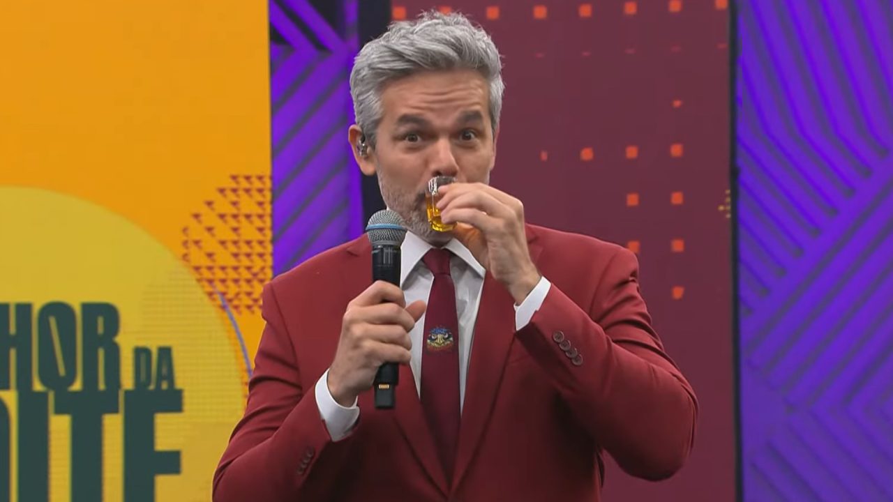 Foto de Otaviano Costa tomando um shot no estúdio do Melhor da Noite