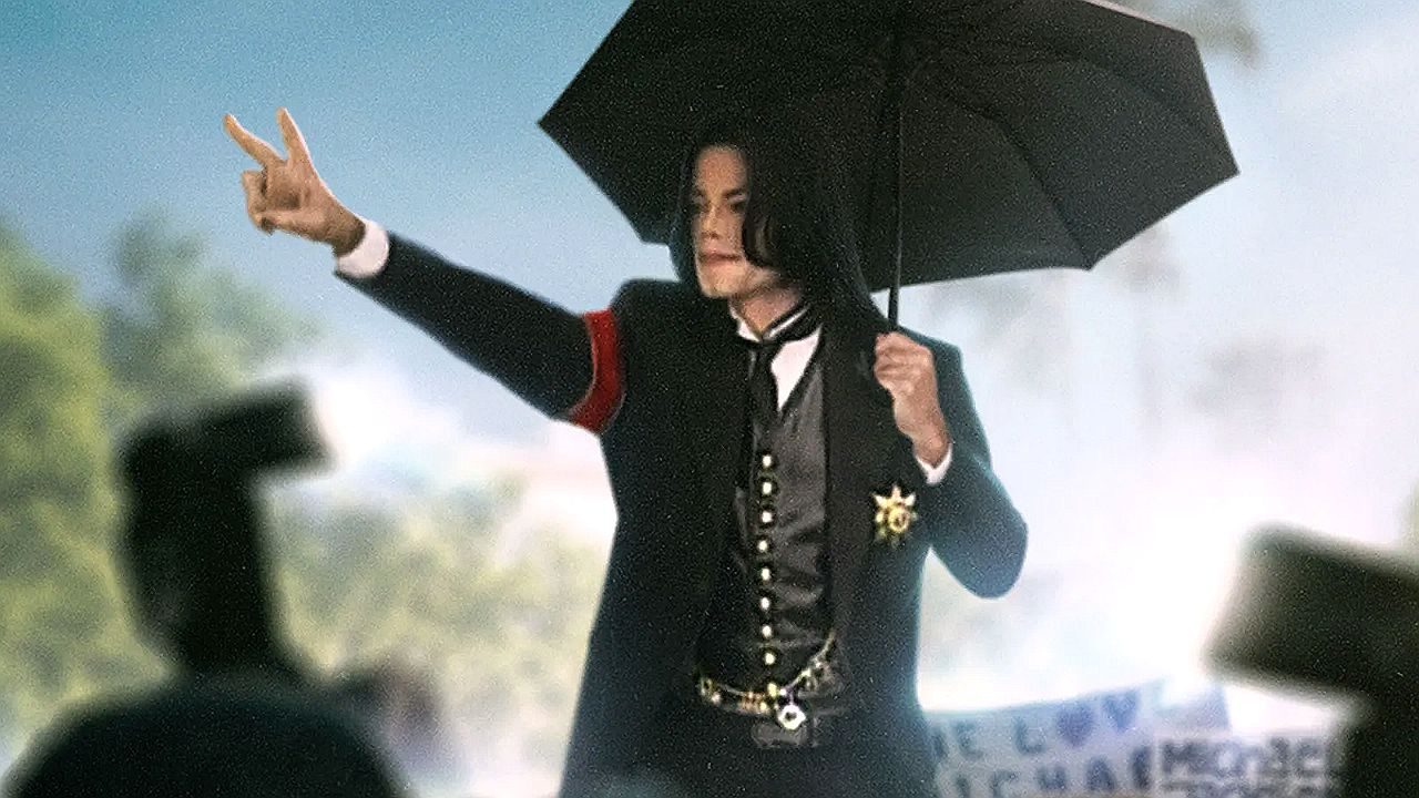 Cantor Michael Jackson com uma roupa preta e um guarda-chuva preto