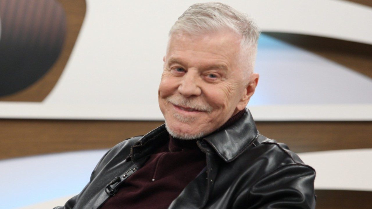 Miguel Falabella de jaqueta preta sorri durante entrevista no programa Roda Viva em estúdio de TV
