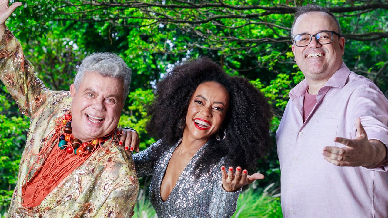 Milton Cunha, Valéria Almeida e Everaldo Marques sorrindo juntos em foto promocional do Carnaval 2025 da Globo