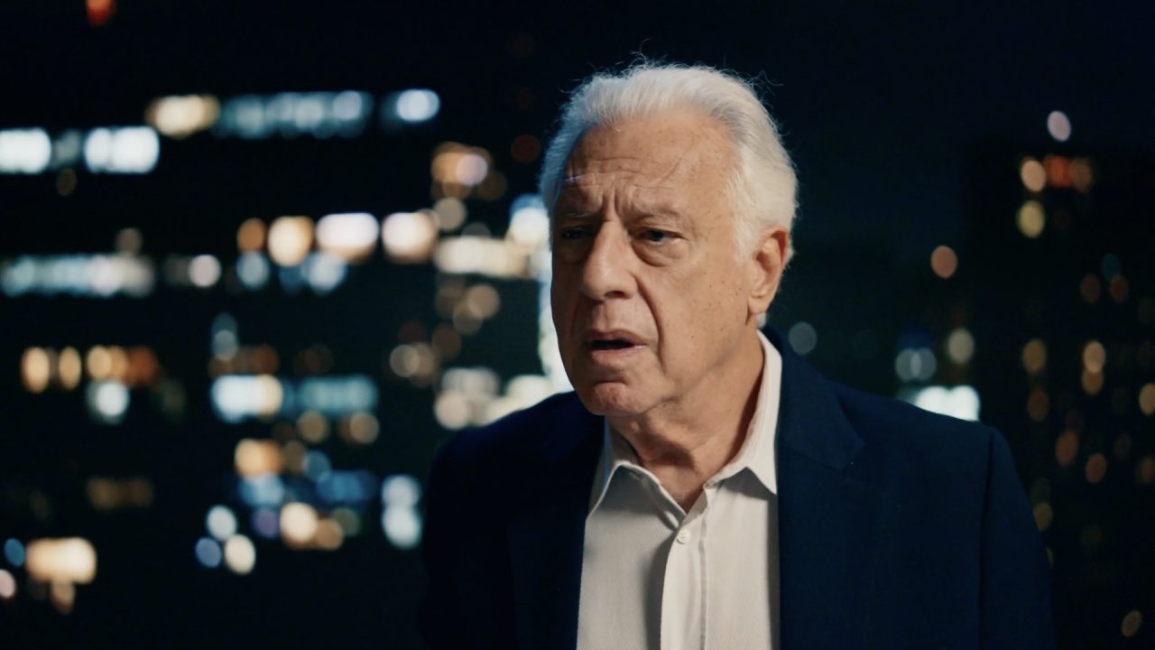 Arthur Brandão, interpretado por Antonio Fagundes, observa a cidade à noite com expressão preocupada em cena de Quem Ama Cuida na TV Globo