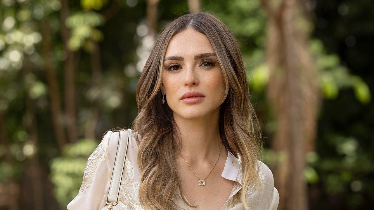 Naiane (Isabelle Drummond) de blusa clara e cabelo solto encara a câmera em foto de divulgação da novela Coração Acelerado