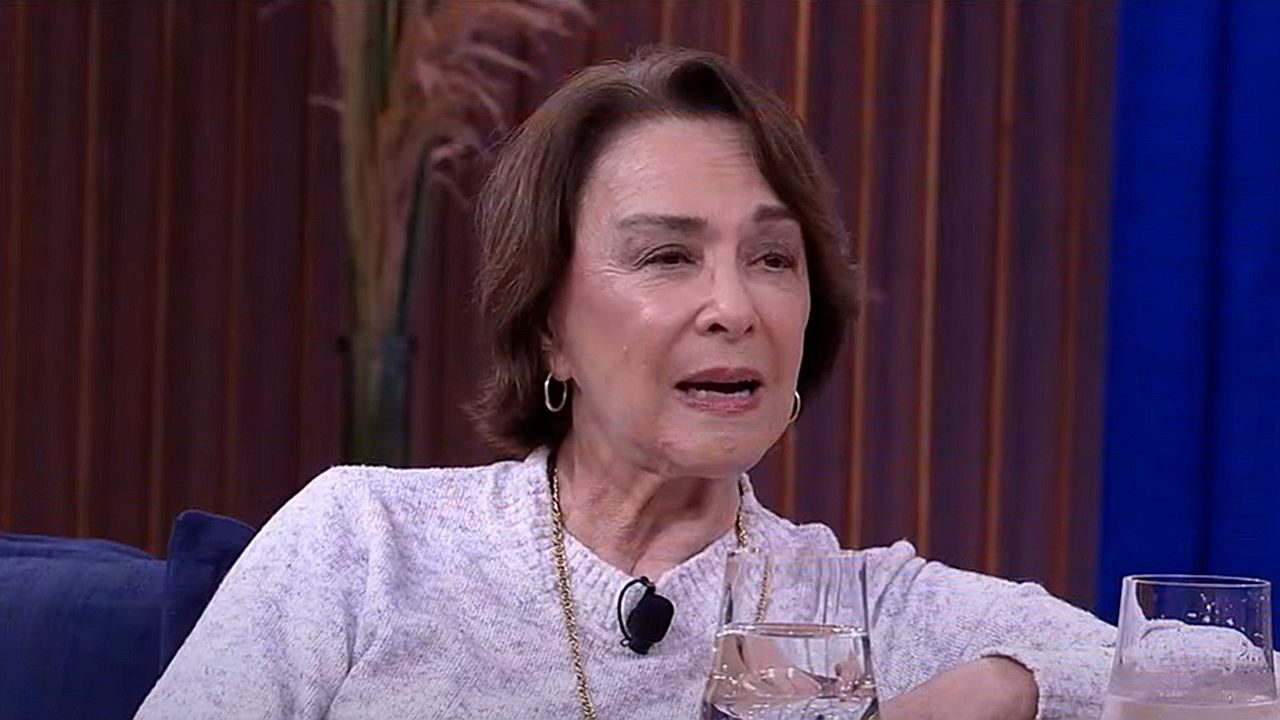Nívea Maria fala durante entrevista em programa de TV sentada em sofá no estúdio