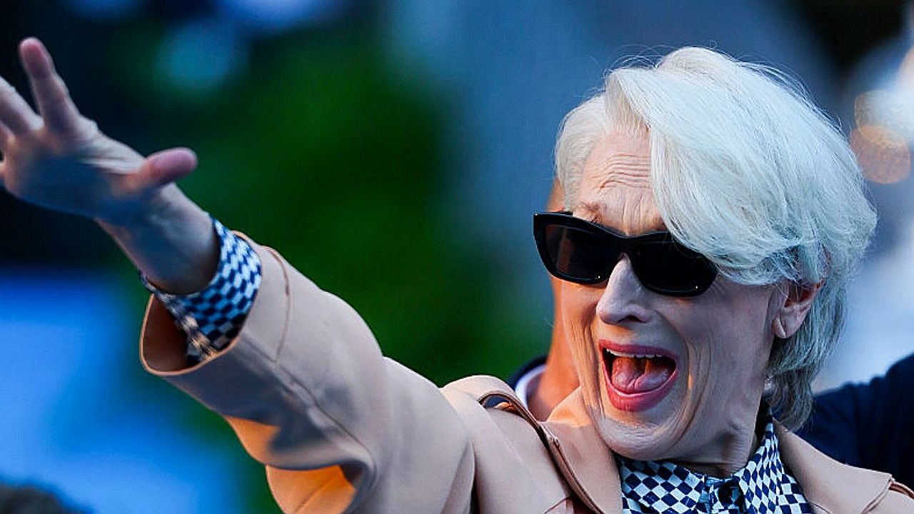 Miranda Priestly com óculos escuros faz gesto para a multidão em cena do filme O Diabo Veste Prada