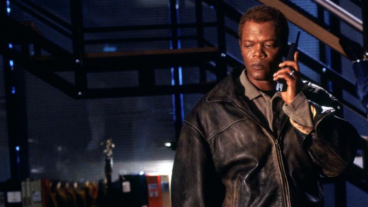 Homem em um escritório escuro com um telefone na mão