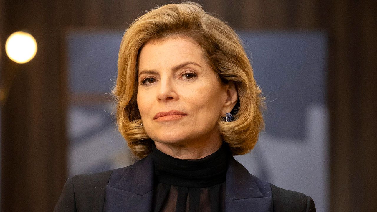 Débora Bloch como Odete Roitman com cabelo loiro e blazer escuro em close-up para o remake da novela Vale Tudo