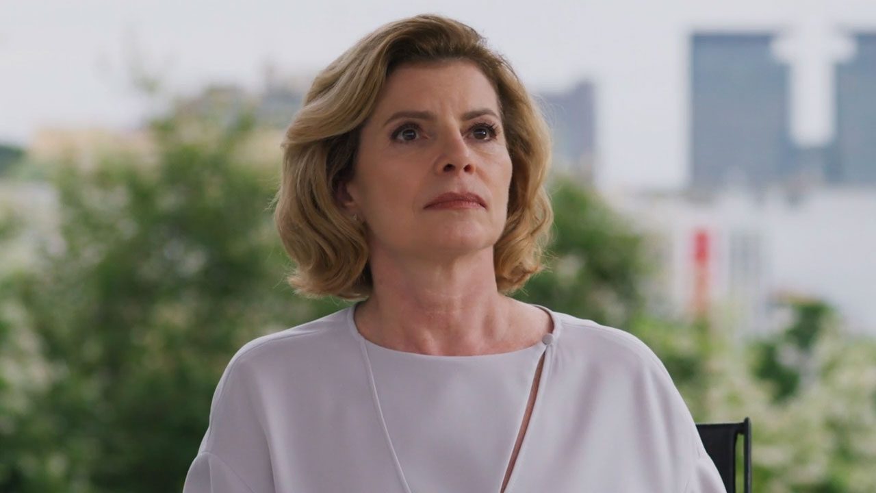 Débora Bloch caracterizada como Odete Roitman olhando séria em cena de Vale Tudo com fundo desfocado