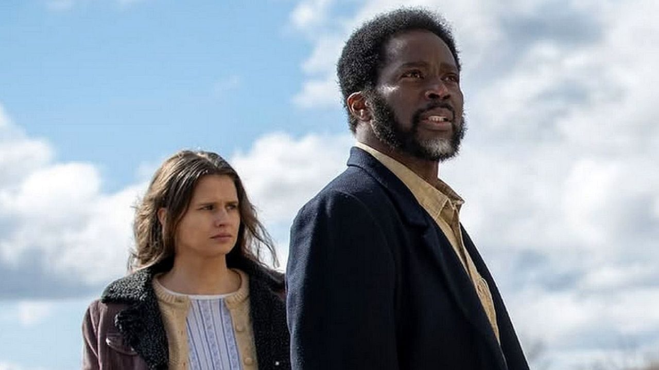 Homem e mulher observam horizonte sob céu nublado em cena ao ar livre de série ou filme