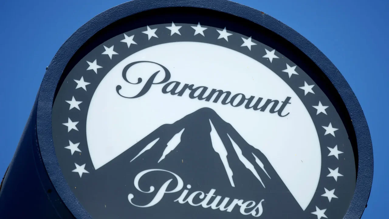 Logotipo da Paramount Pictures em um letreiro circular, exibindo uma montanha central estilizada cercada por estrelas, sobre fundo azul claro.