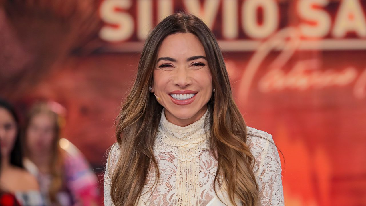 Patricia Abravanel sorrindo no palco do Programa Silvio Santos com plateia ao fundo no SBT