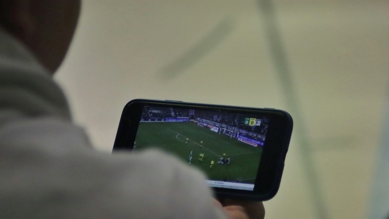 Foto de pessoa assistindo a um jogo da Copa do Mundo em seu celular