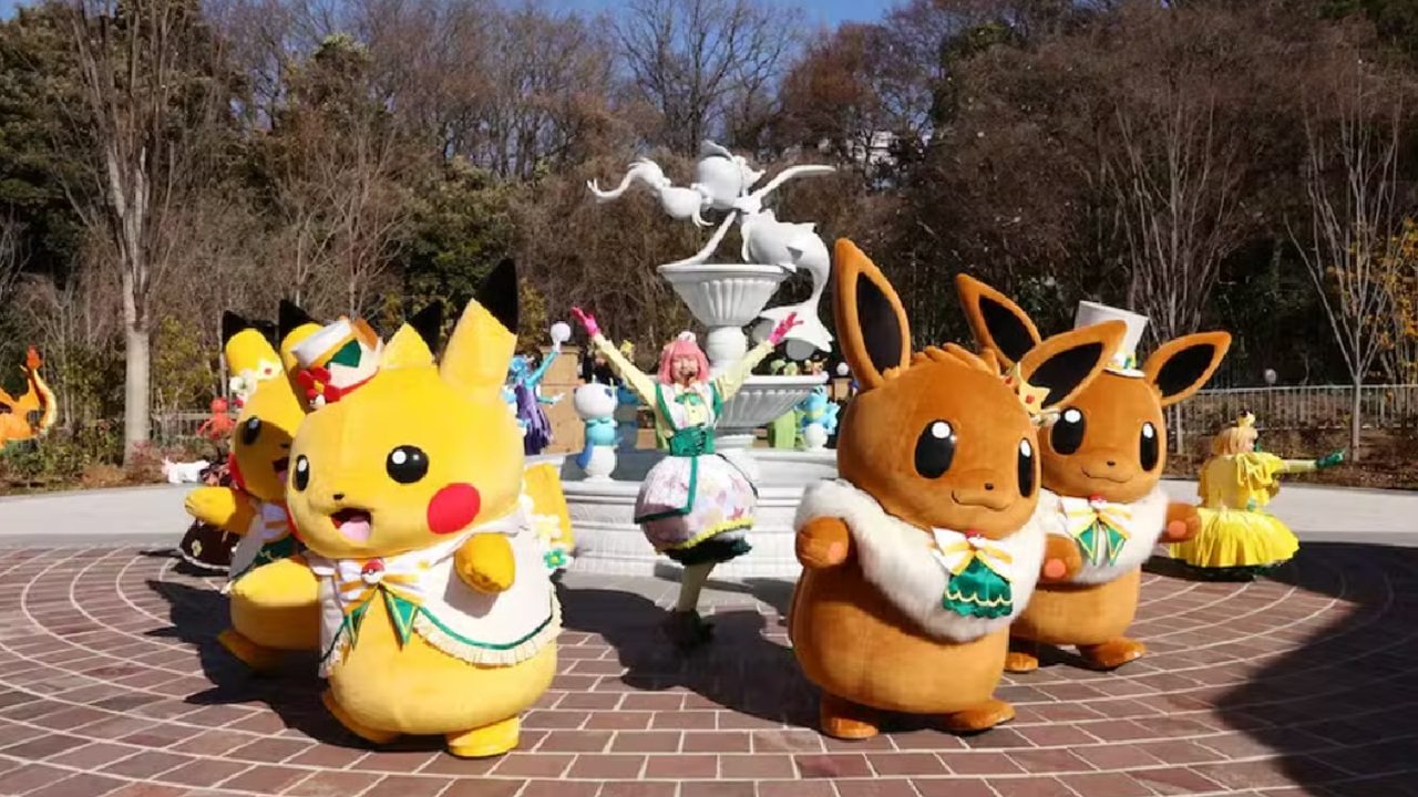 Personagens Pikachu e Eevee em fantasia participam de desfile com dançarinos em parque temático durante apresentação ao ar livre