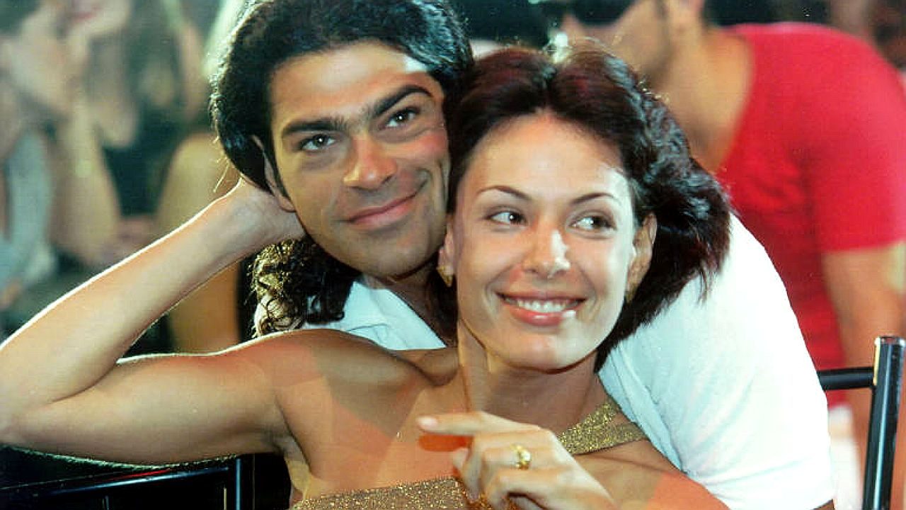 Eduardo Moscovis abraça personagem sorridente em cena romântica da novela Por Amor