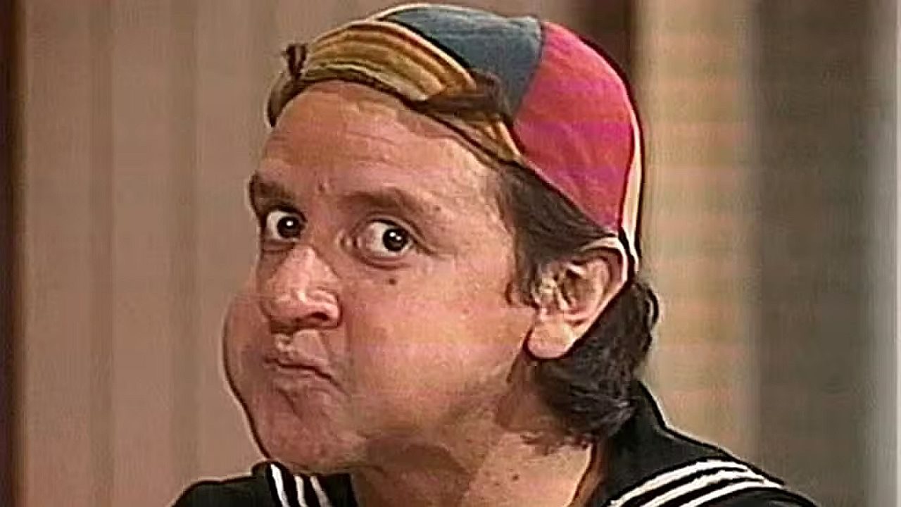 Quico com boné colorido e expressão surpresa em cena do seriado Chaves