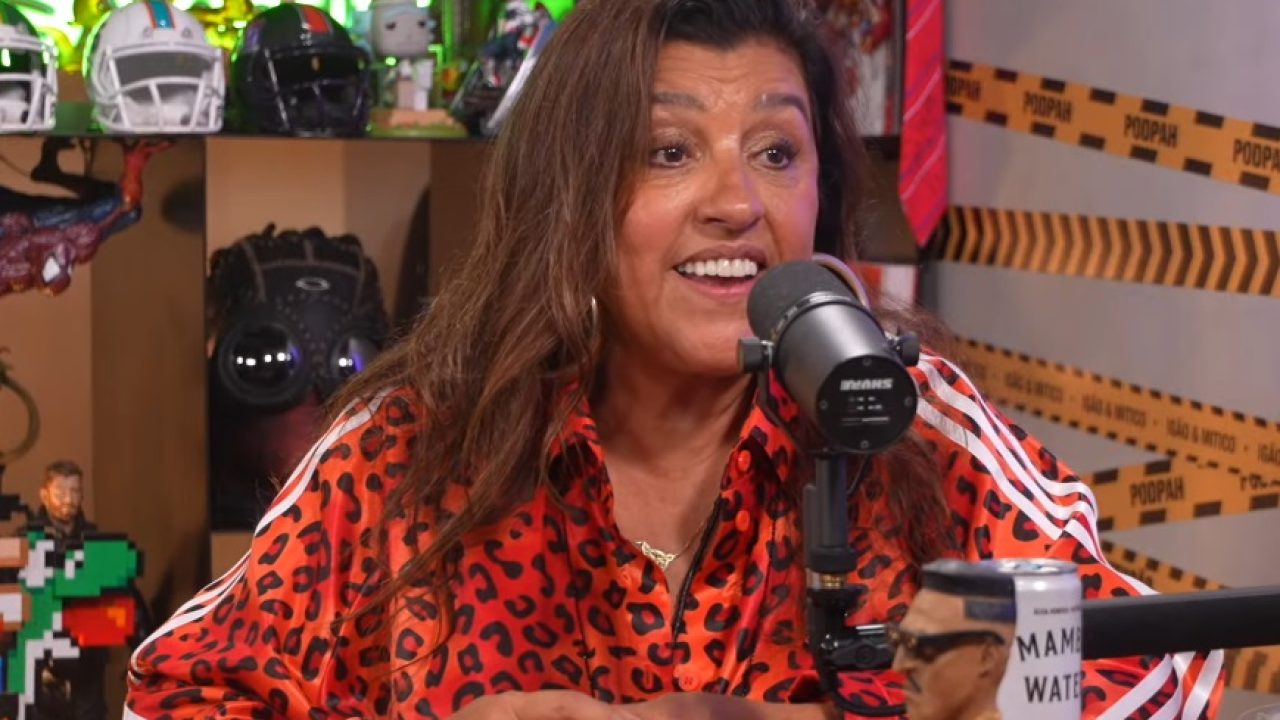 Regina Casé durante participação no podcast Podpah, sentada à mesa com microfone à frente