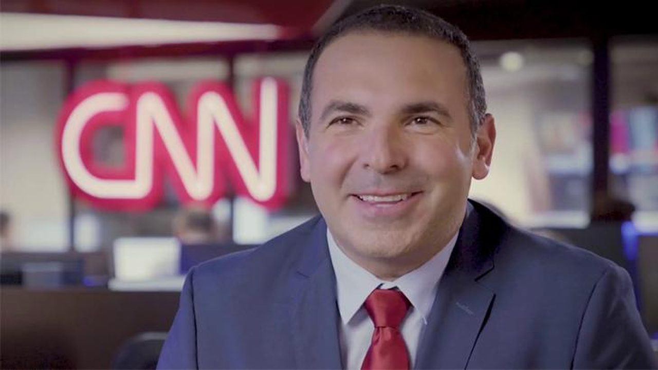 Reinaldo Gottino com uma grande logo da CNN no fundo