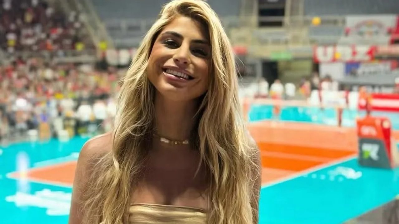 Renata Heilborn com uma quadra de vôlei no fundo