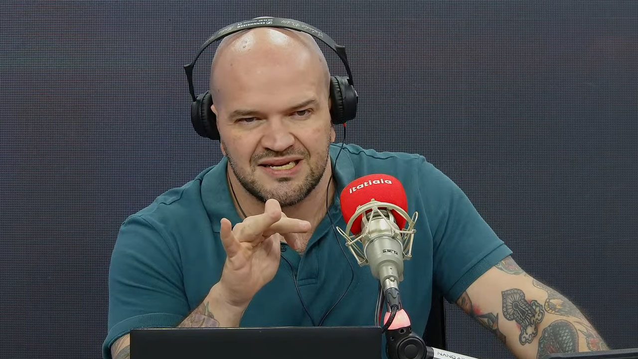 Renato Rios Neto com fones de ouvido falando ao microfone da Rádio Itatiaia durante apresentação do Itatiaia Patrulha