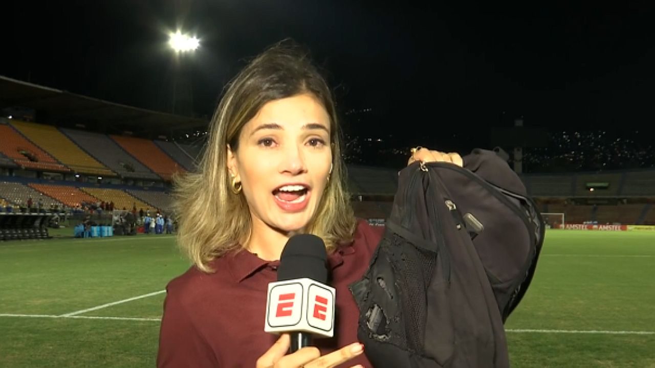 Repórter da ESPN mostra mochila rasgada durante transmissão em estádio de futebol à noite