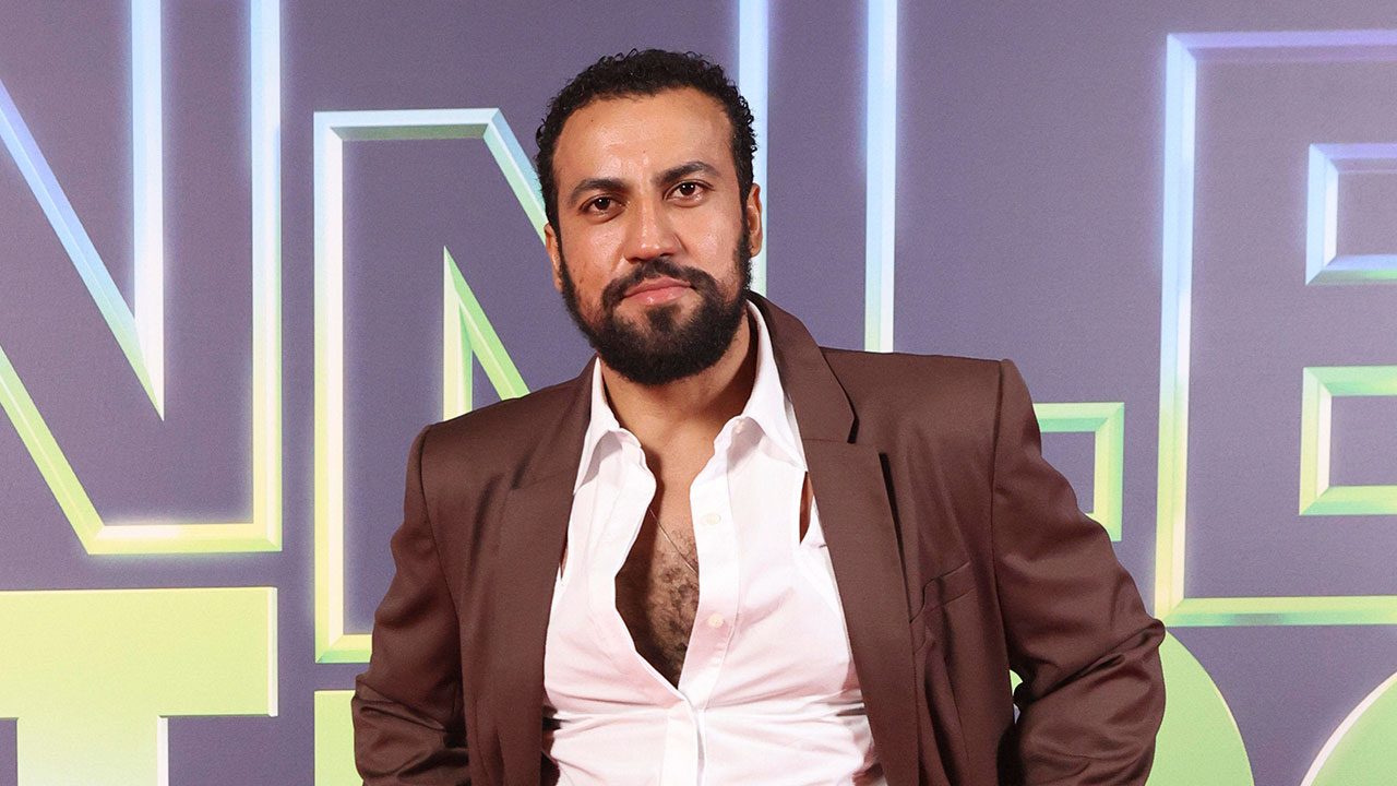 Ricardo Teodoro com blazer marrom e camisa aberta no evento de lançamento do remake de Vale Tudo