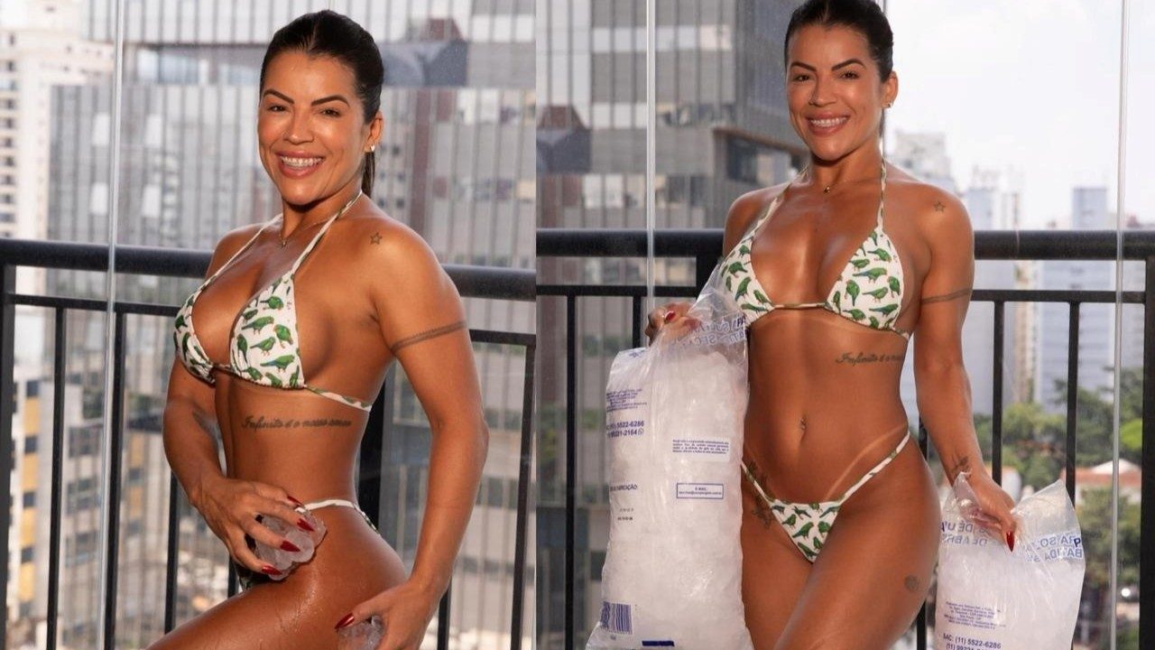 Rosana Ferreira sorri usando biquíni com estampa de pássaros, segura sacos de gelo em uma sacada, exibe corpo bronzeado e tatuagens, prédios ao fundo clara