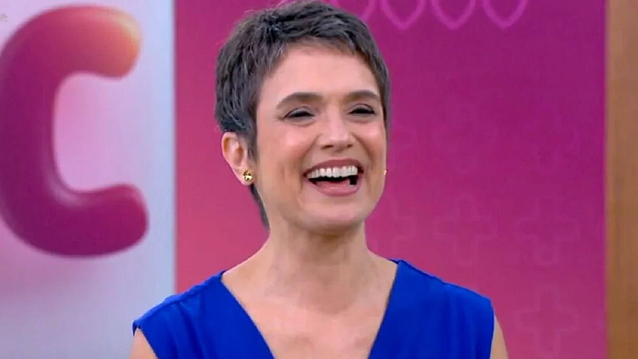 Sandra Annenberg sorri durante participação em programa da TV Globo usando vestido azul no estúdio