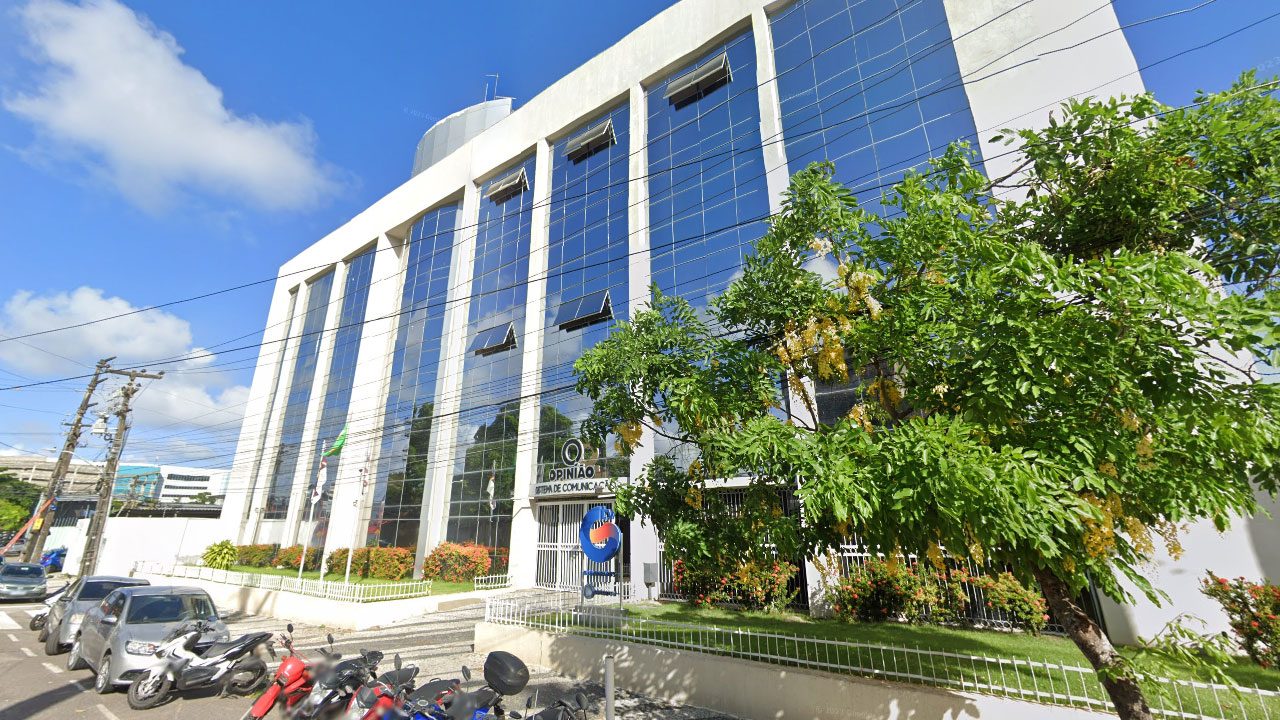 Fachada do prédio da TV Guararapes afiliada da Record em Pernambuco com logo Opinião Sistema de Comunicação na entrada