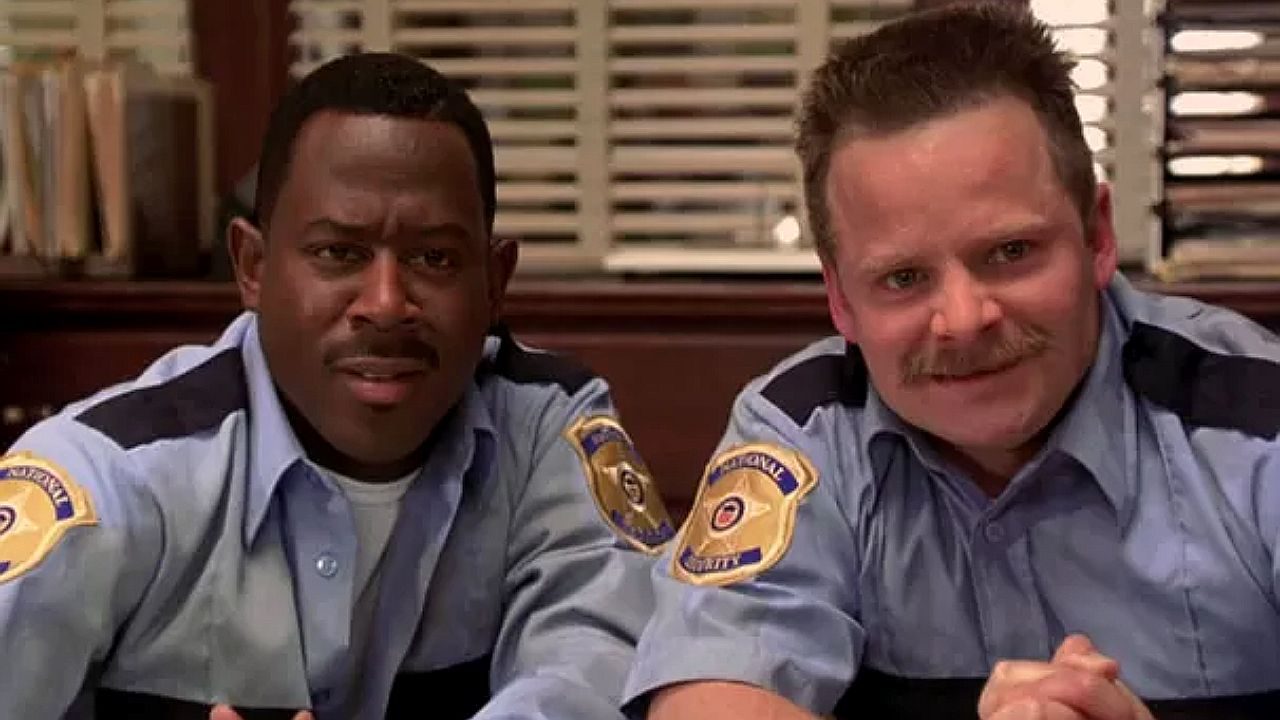 Martin Lawrence e Steve Zahn com uniformes de policiais observam algo com expressão surpresa em cena de comédia policial