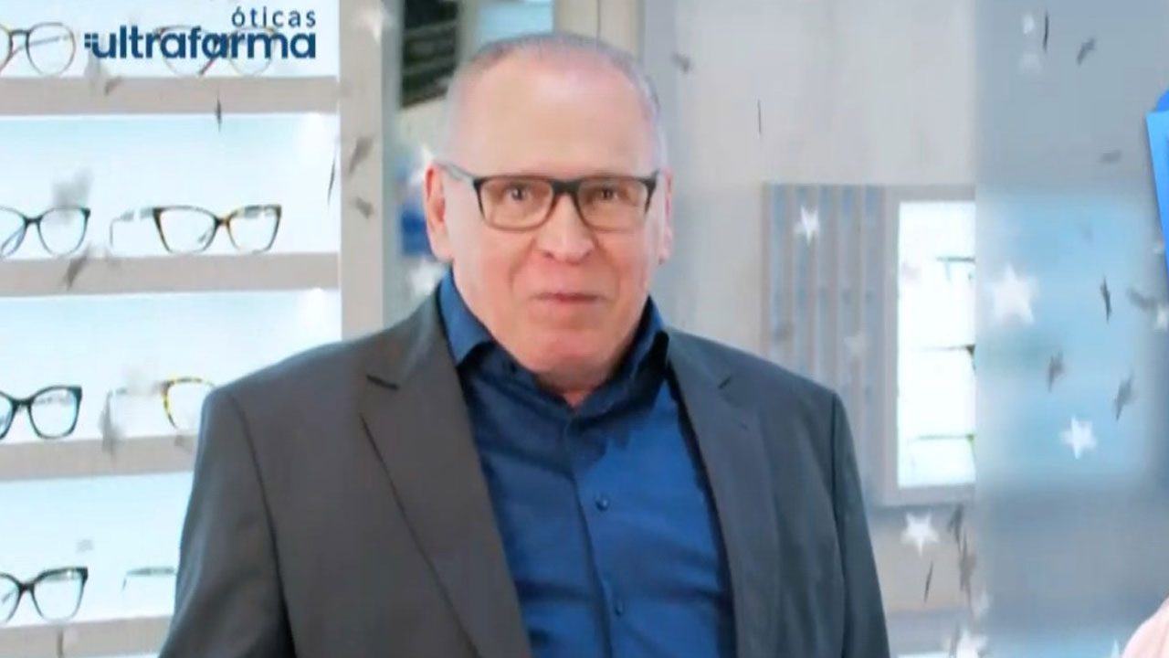 Sidney Oliveira usa óculos e terno escuro em gravação de campanha das Óticas Ultrafarma