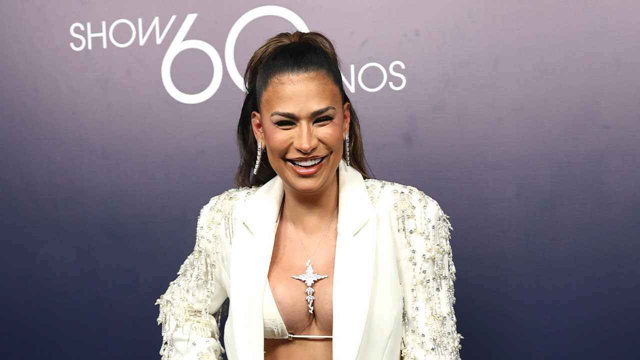 Simone Mendes sorridente em frente ao painel do Show 60 Anos da Globo durante evento comemorativo