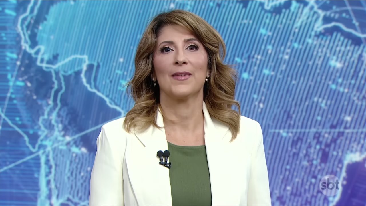 Simone Queiroz apresenta o SBT Brasil diante de painel com mapa digital no estúdio de telejornal da emissora